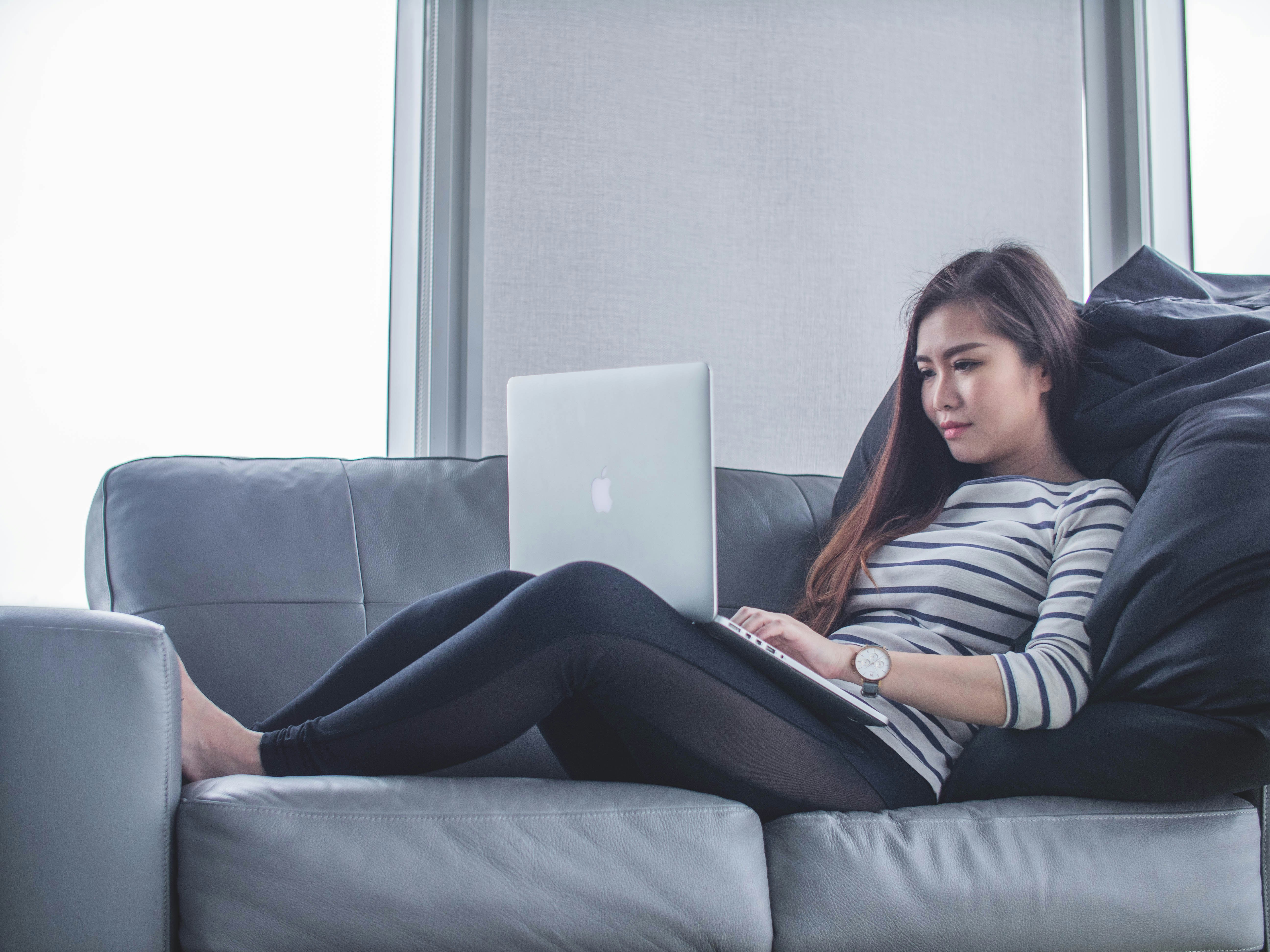 Woman sitting on her couch with a laptop